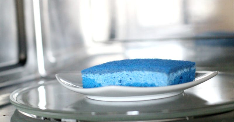 Чистка микроволновки с помощью губки и средства для мытья посуды